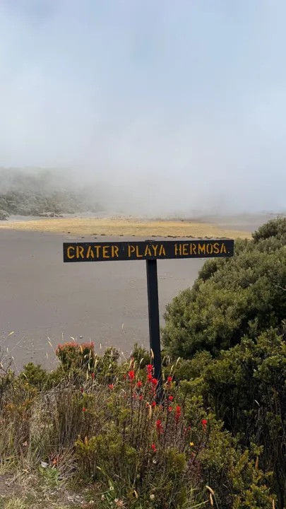 Playa Hermosa crater sign beside a misty volcanic landscape