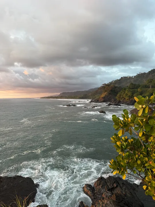 Waves meeting a rocky coast beneath storm clouds