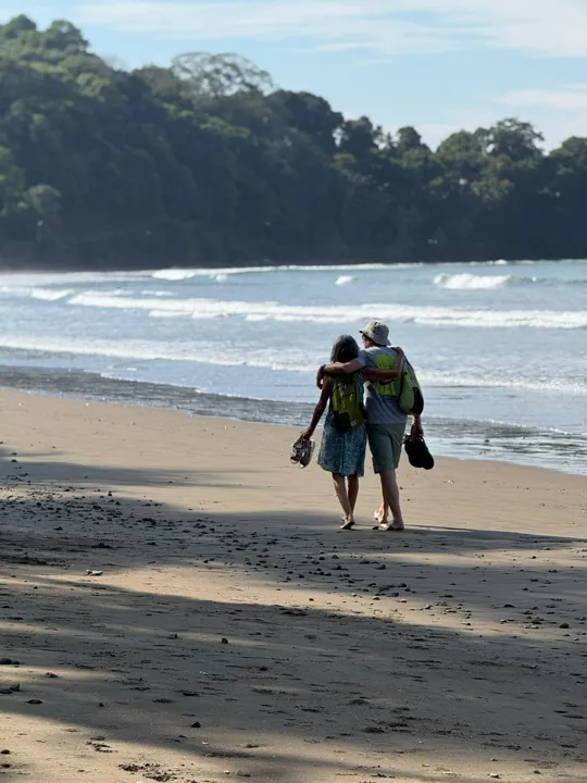 Two people walking together along the shoreline