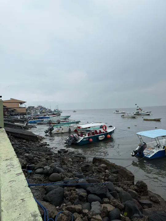 Small boats moored along a rocky harbor
