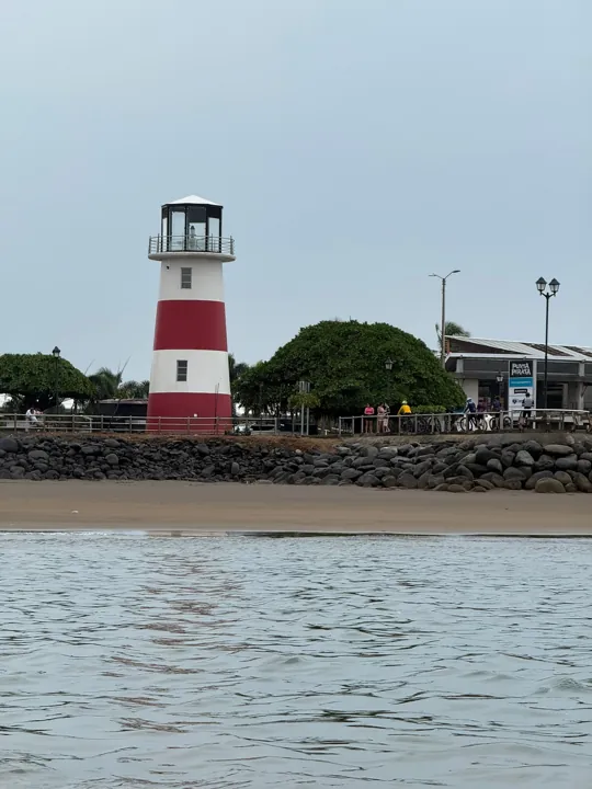 Red and white lighthouse beside the harbor