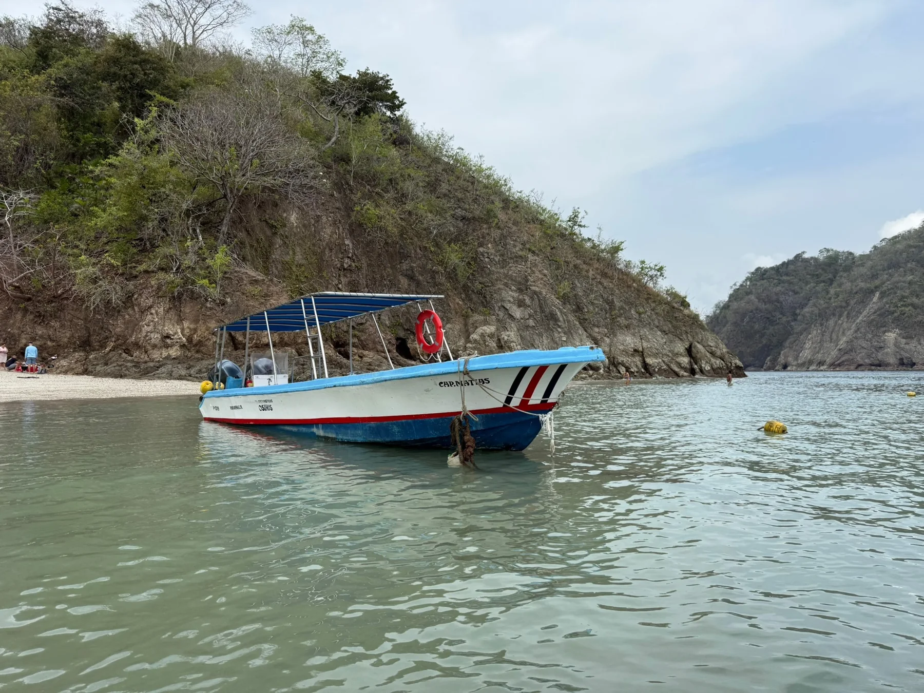 Tour boat floating in a sheltered rocky bay