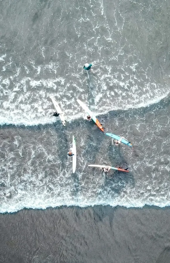 Surfers and breaking waves from above